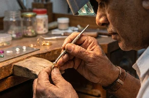 Jeweller hand-setting a stone into a ring
