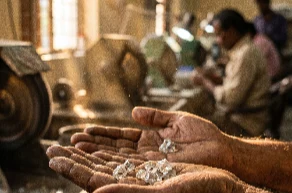 Rough diamond crystals held in open palms
